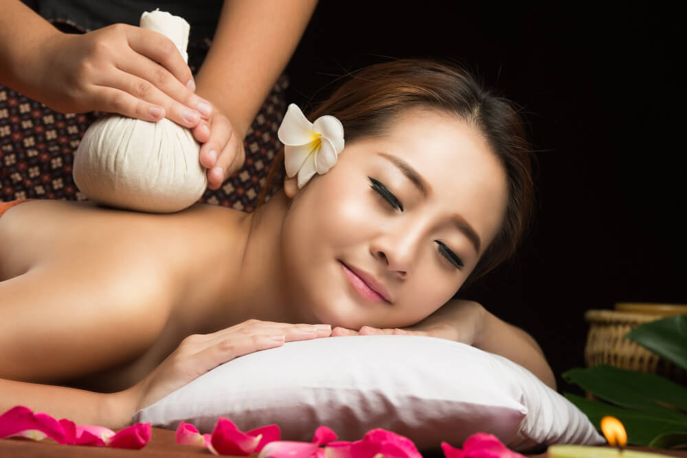 Asian Woman Getting Thai Herbal Compress Massage Spa